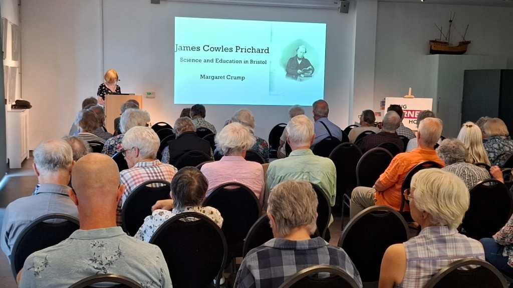 Engaged crowd seated before Margaret M. Crump presenting "James Cowles Prichard: Science and Education in Bristol"